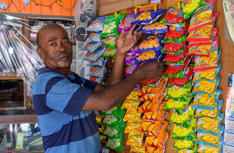 Latchman Appadoo organising a section of his grocery shop in Whim Village