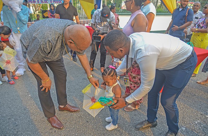 WITH Easter just a few days away, President, Dr Irfaan Ali on Thursday hosted an Easter Fair on Main Street in front of his official residence, which attracted groups of parents and their children. The children were presented with kites and delicious goodies, which were distributed by Minister of Public Works, Bishop Juan Edghill and Minister of Tourism, Industry and Commerce, Oneidge Walrond. Music by the Guyana Police Force Band filled the air and there were fun games with prizes. Additionally, the Easter Bunny was on site for those desirous of taking photos (Yohan Savory photos)