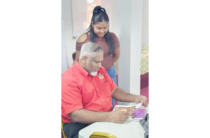 Chief Executive Officer of the Small Business Bureau Mohamed Shazim Ibrahim reviews a participant’s work during the Digital Readiness training