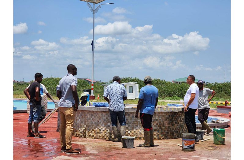 Minister of Housing and Water, Collin Croal (at right), speaking with contractors doing renovation works on Saturday where the accident occurred Friday night