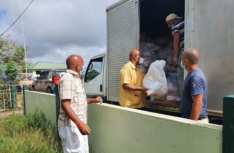 Public Works Minister, Juan Edghill, assisting with the distribution of hampers to the flood-affected residents of Kwakwani earlier in the month