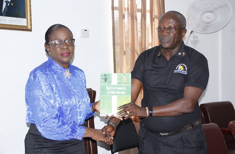 Education Minister Nicolette Henry receiving the report from the ministry’s Permanent Secretary Vibert Welch.