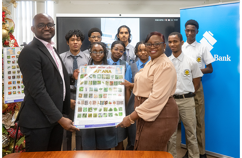 Students from St. Stanislaus College and Brickdam Secondary, Dr Kofi Dalrymple, Presidential Adviser to the Ministry of Education receive the charts from Jonelle Dummett, Manager - Marketing & Communications, Republic Bank (Guyana) Limited