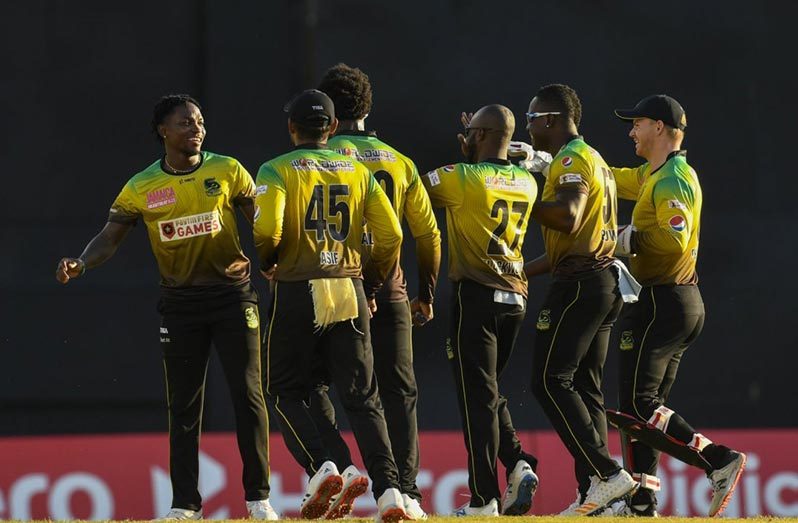 Pacer Fidel Edwards at left is congratulated by teammates after bowling Warriors opener Brandon King with the first ball of the match.(CPL photo)