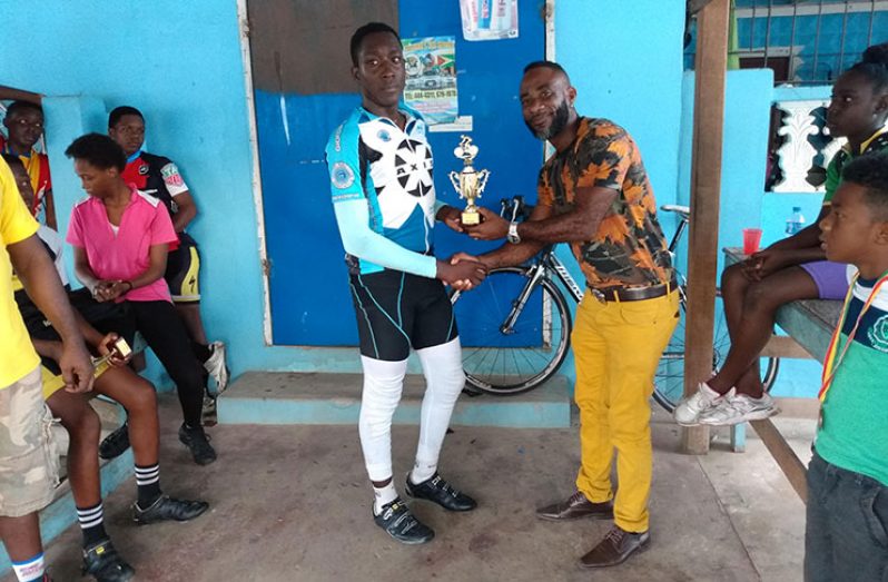 Winner of the 10-lap circuit race for School Boys 13-16, Elijah Rutherford receives his trophy from Chochezi Ngqondo of Cho's Bar and Grill.
