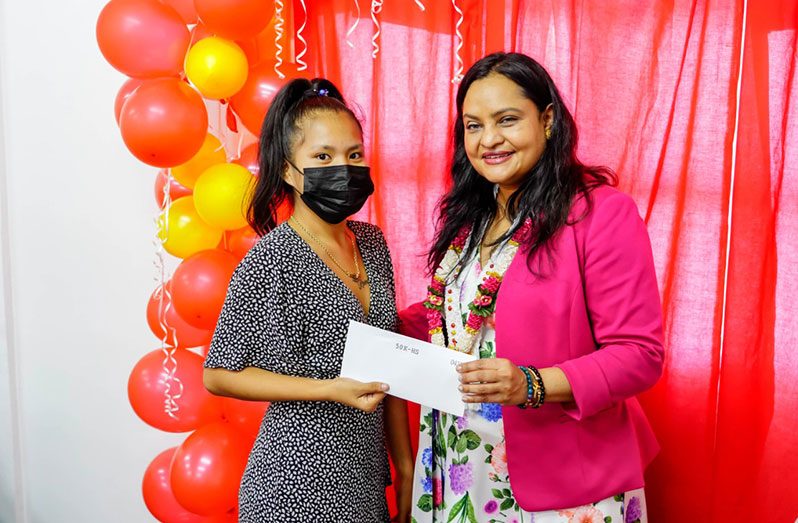 A budding businesswoman receives her empowerment grant from Minister of Human Services and Social Security Dr. Vindhya Persaud