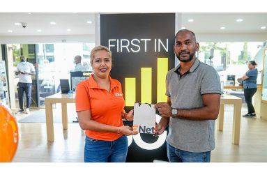 Co-Director of Kares One Guyana T10 Blast, Yusuf Ali, collects the cellphones from Nichola Parasram, Trade mobile coordinator at Enet