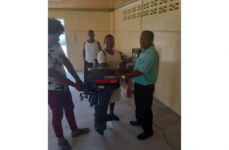 The Community Health Worker accepting the outboard engine