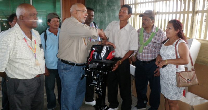 President Ramotar hands over the outboard engine to Toshao Lloyd Perreira