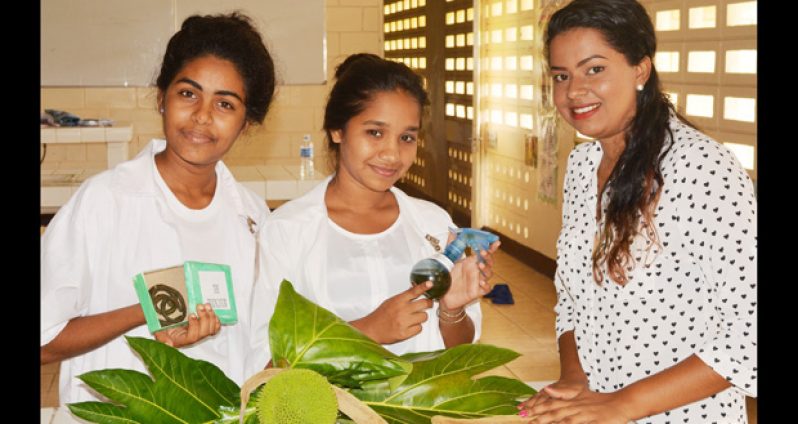 16-year-old Darshanie Nanhu (right), a student of the Bygeval Secondary School, poses with a bottle of insect repellent she invented using a toxin found in the flower of the Katahar tree. The project won the 2016 Science, Mathematics and Technology Fair on Friday. Others in photo are Dolly Sooknanan, 16, (left) another student who worked on the project with Darshanie and helped her present it at the fair, and teacher Jaishree Nanku, who managed the students and helped create the display for the project (Ivan Bentham photo)