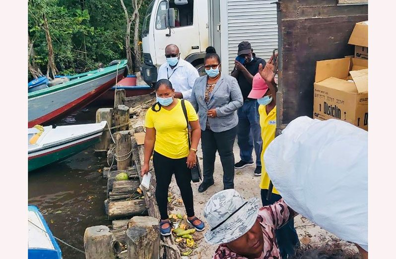 Chairperson Vilma De Silva and the Prime Minister's Representative Arnold Adams watch as  hampers for  residents of the Pomeroon River are offloaded from a truck