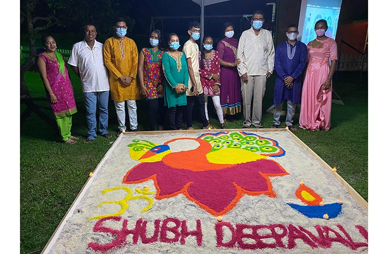 Residents standing next to a Rangoli
