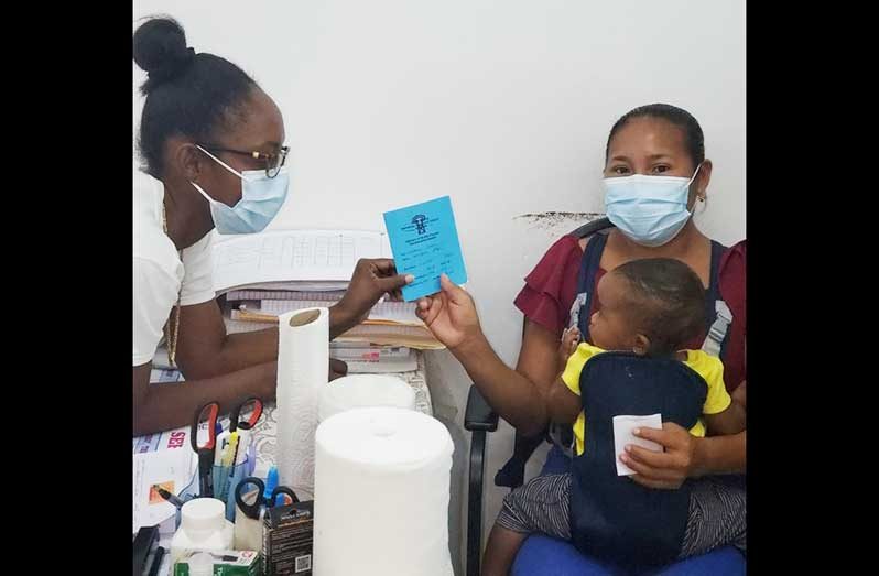 Toshao of Karisparu, Candacy Evans, receiving her COVID-19 vaccination book after receiving the single-shot COVID-19 vaccine