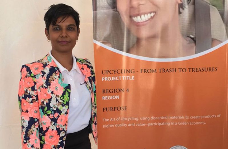 Owner Christine DeCambra with a banner for her upcycling project that was given a grant last year