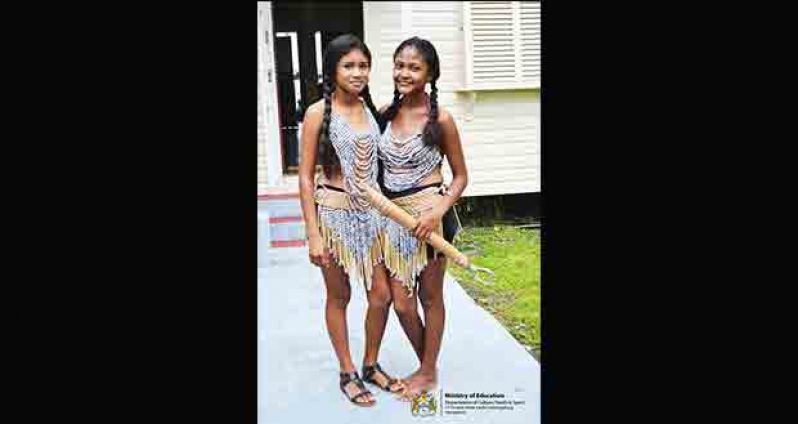 Amerindian girls in traditional clothing at the opening of the exhibition. (Ministry of Education photo)