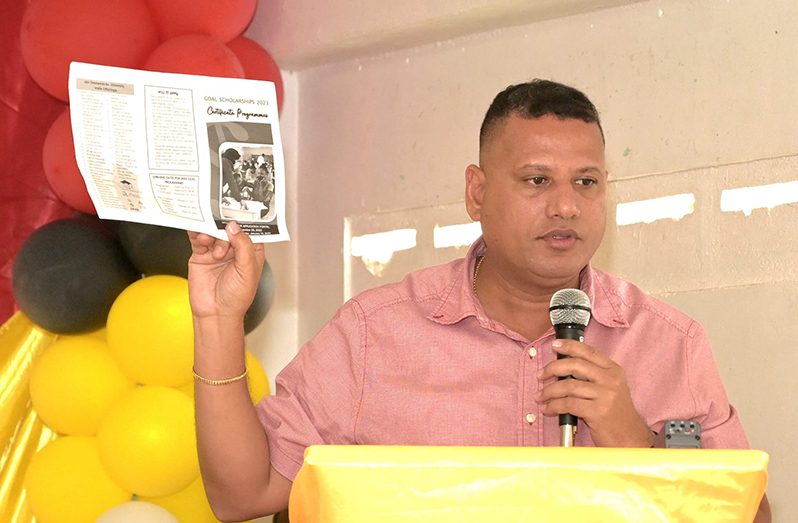 Minister of Housing and Water, Collin Croal, displays a GOAL brochure during his address to residents of Region One