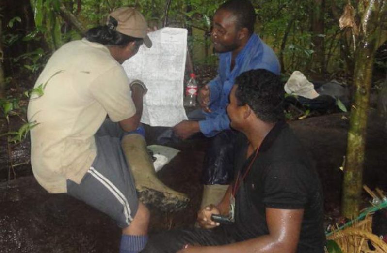 Geologists examine a map during an exploration exercise in Guyana