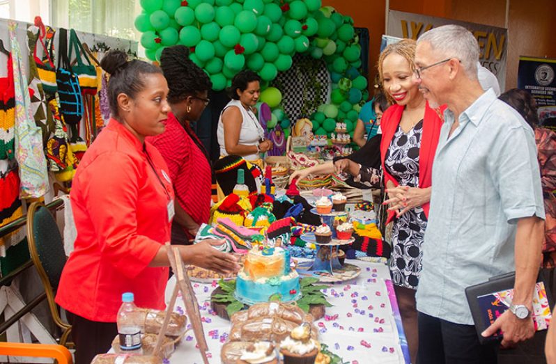 Minister of Business Dominic Gaskin and founder of Women in Business Expo Sonia Noel interacting with one of the exhibitors who was exhibiting her baked products (Delano Williams photo)
