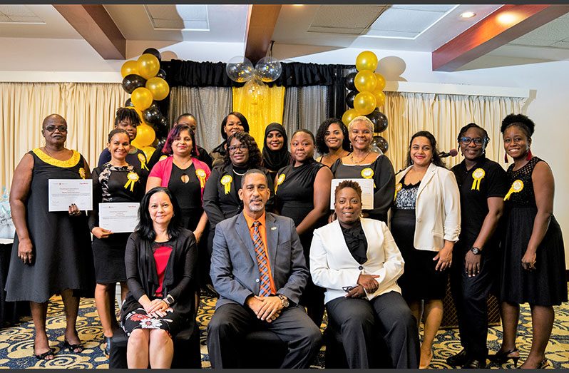 Graduates of the GWIM programme share a moment with officials (seated) following a simple graduation ceremony (ExxonMobil photo)
 