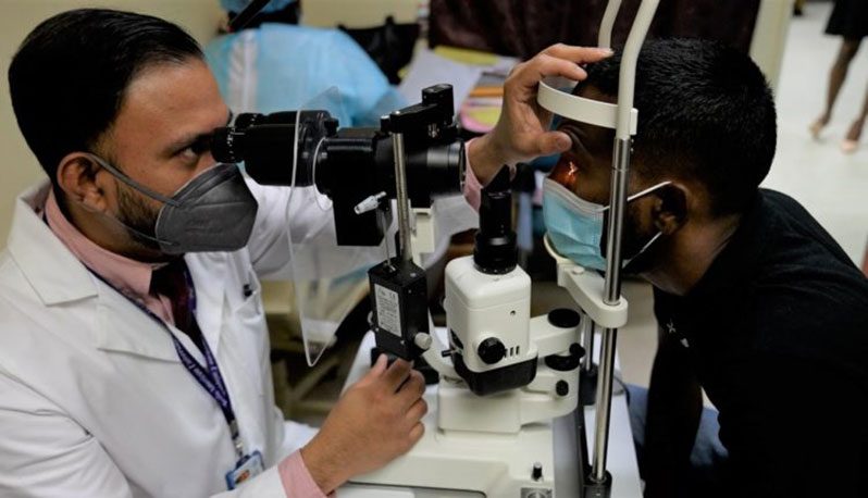 GPHC Head of the Department of Ophthalmology, Dr. Shailendra Sugrim (left), conducting an examination on Shameer Nazeer, a patient who benefitted from a corneal transplant in May this year