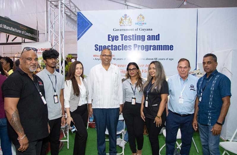 Dr The Honourable Frank Anthony, Minister of Health, joins staff of Da Silva’s Optical, including Optometrists Dr Shannon Da Silva (grey suit vest) and Dr Philip Da Silva (light blue shirt), along with H.E. Mr Dharamkumar Seeraj, Guyana’s High Commissioner to India (dark blue shirt), during a visit to the Eye Testing and Spectacles Programme booth at the International Building Expo.