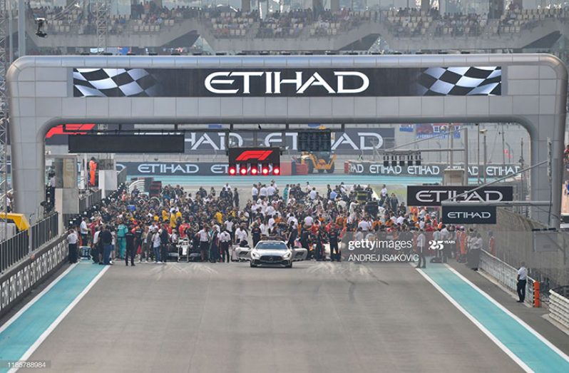 F1 cars and mechanics are pictured on the grid at Yas Marina Circuit in Abu Dhabi, ahead of the final race of the Formula One Grand Prix season, on December 1, 2019. (Photo by Andrej Isakovic/AFP) (Photo by Andrej Isakovic/AFP via Getty Images)