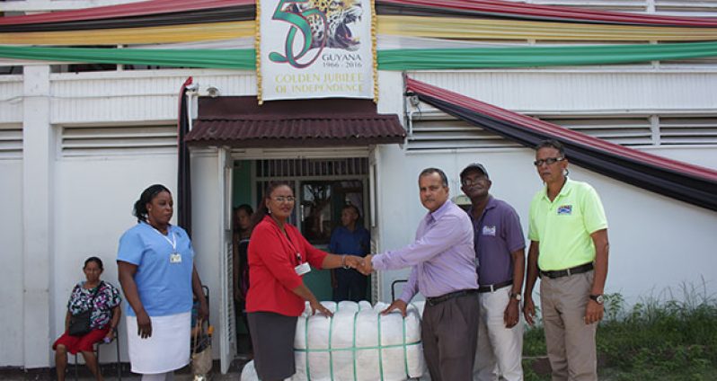 Silochanie Singh receives the donation from CEO of Food for the Poor, Kent Vincent. Others in photo are Shaundelle Inniss, Wayne Hamilton and Compton Giddings