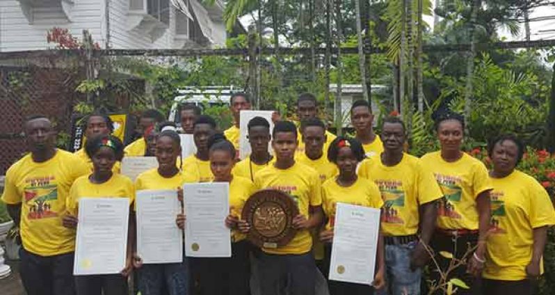 US-based former Guyanese athletic coach, Mark Webster (left), poses with the Fort Wellington team