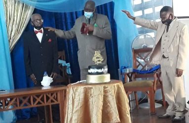 Bishop John Smith of Central Assembly lays hand on Rev. Gittins as Pastor Clive Cox extends a hand in blessing.