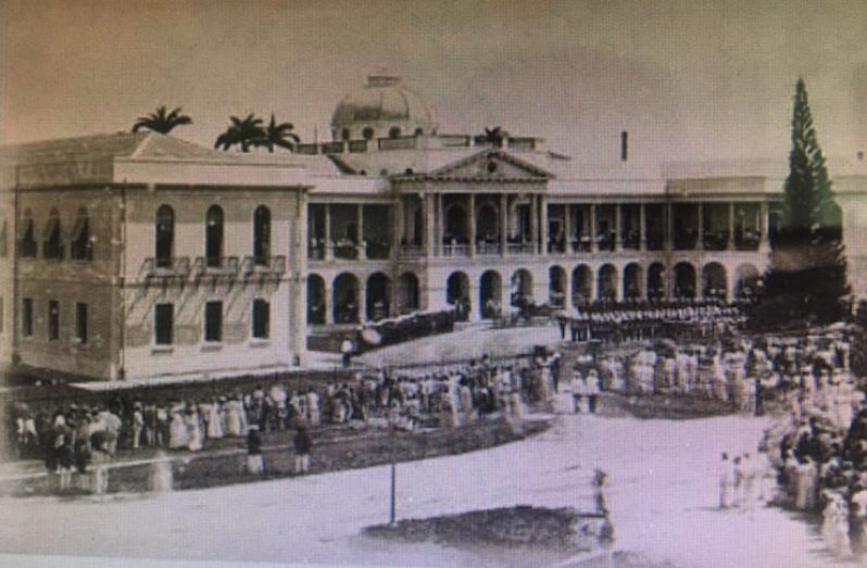 The historic Public Buildings on Brickdam, over a century ago. A sitting of the Legislature (Parliament) where scores of citizens converge on the pavement
