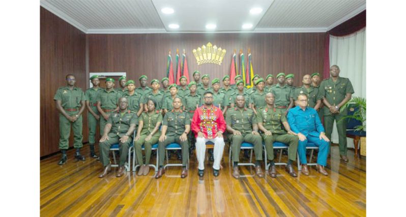 President Dr. Mohamed Irfaan Ali (centre) is flanked by Chief of Defence Staff, Brigadier Omar Khan; Colonel Sheldon Howell; and Director of the National
Intelligence and Security Agency and National Security Advisor, Captain Gerry Gouveia (Ret’d), along with the 22 newly commissioned Second Lieutenants of
the Guyana Defence Force (GDF) following the presentation of instruments of commission and state warrants at State House on Friday (DPI photo)