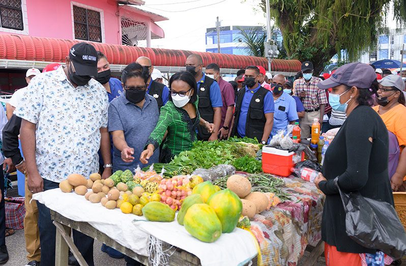 President Dr. Irfaan Ali; Finance Minister, Dr. Ashni Singh and Minister of Tourism, Industry and Commerce, Oneidge Walrond, examine produce on sale at the Leonora Market (Delano Williams photo)