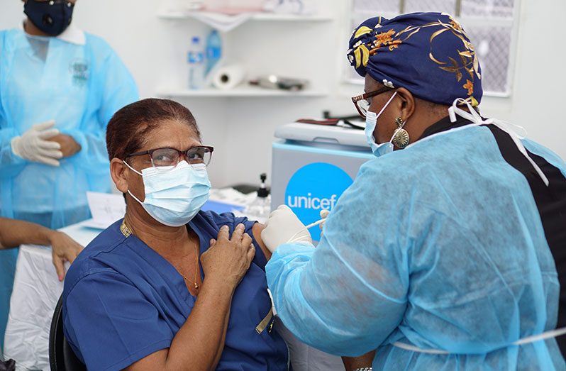 Nurse Tamika Threlfall, administers a shot of the Oxford/AstraZeneca vaccine to a senior citizen on Sunday at the Ministry of Health secretariat on Brickdam, Georgetown (Elvin Croker photo)