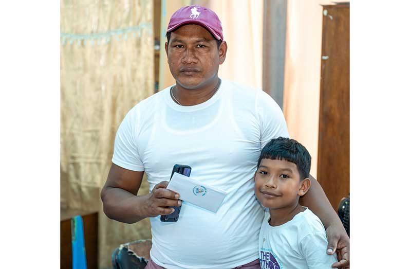A father with his son after receiving the cash grant