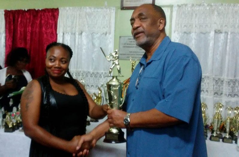 A member of the winning female cricket team (Westside) collects the team’s prize from Dr. Vincent Adams