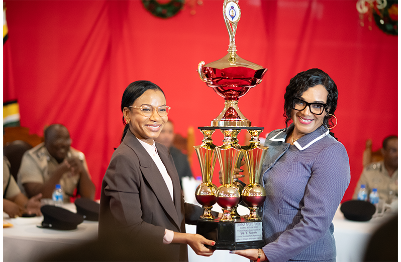 Minister of Home Affairs Oneidge Walrond presents the coveted Best Cop title was awarded to Deputy Superintendent Fiona Fredricks, the Head of the Narcotics Branch, whose leadership and operational results have positioned the unit as a national standout (Delano Williams photo)