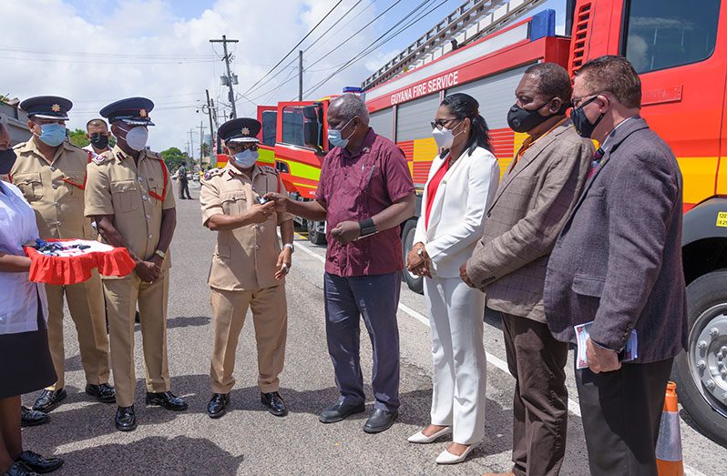 Minister of Home Affairs, Robeson Benn, handing over keys to the new fire tenders to Fire Chief, Kalamadeen Edoo on Thursday (Delano Williams photo)