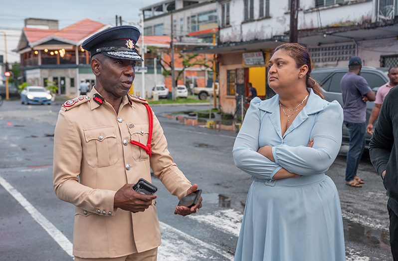 Education Minister, Priya Manickchand receives an update from acting Fire Chief, Gregory Wickham (Delano Williams photos)