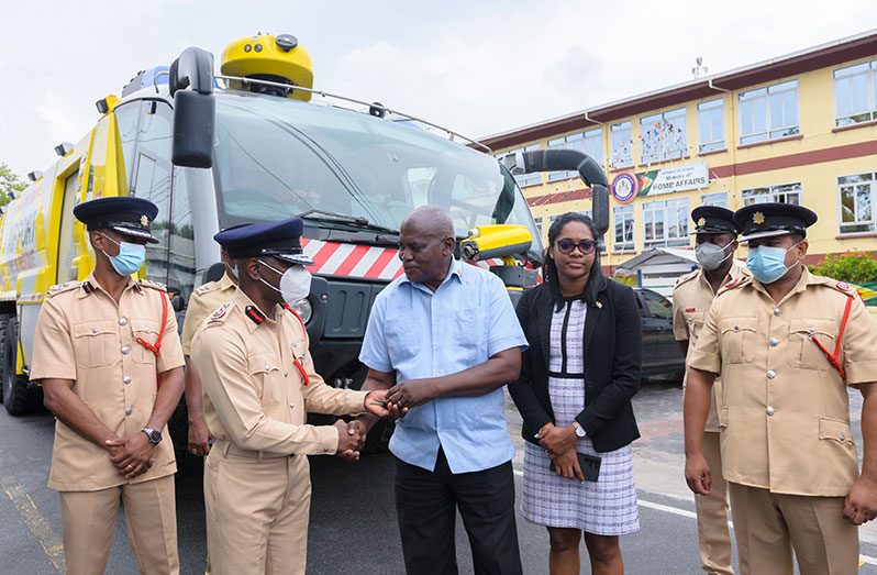 Minister of Home Affairs, Robeson Benn, hands over the keys to the new equipment to Fire Chief (ag) Gregory Wickham, on Tuesday, as other officials look on (Delano Williams photo)