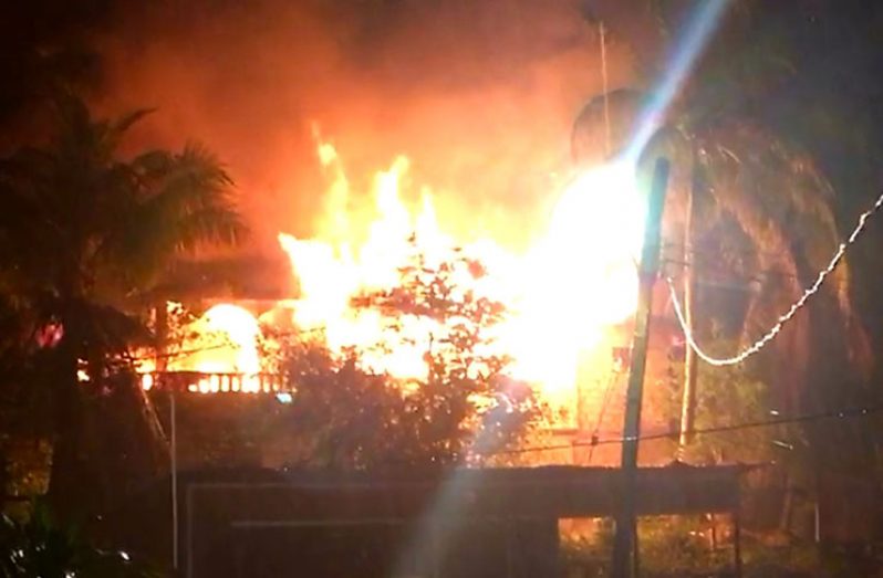 The two-storey house being destroyed by fire