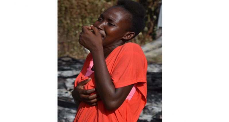A mother's agony: Sydelly reacts upon learning that her house was completely destroyed. (Delano Williams photo)