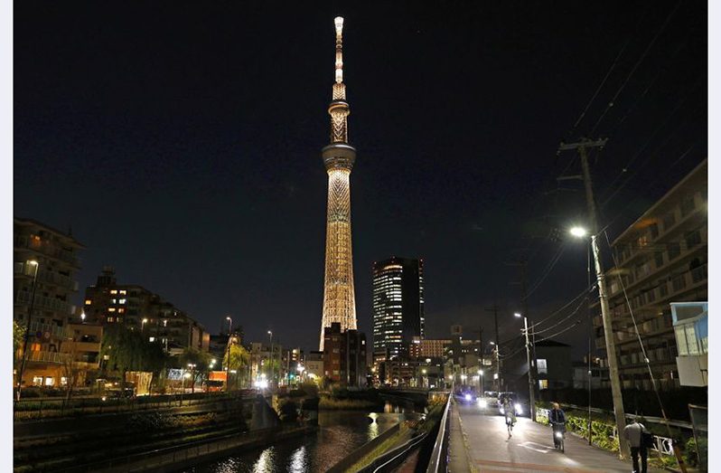 The Tokyo Skytree is illuminated with the colour of the Olympic Torch to mark 100 days until the start of the torch relay for the postponed Olympics. (Reuters)