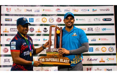 Minister of Culture, Youth and Sport, Charles Ramson Jr. (right) hands over the trophy to the captain of the 2024 champions, Leon Johnson