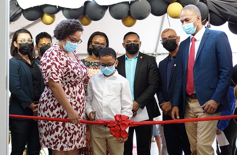 Chief Executive Officer of ‘Floor It Guyana’, Andre Cummings (right) cutting the ribbon with his son and wife