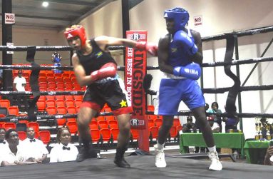 Nisir Dean (left) from the Bahamas about to be floored by Guyana’s Lekiem Amores in the second round on Friday night (Sean Devers photos)
