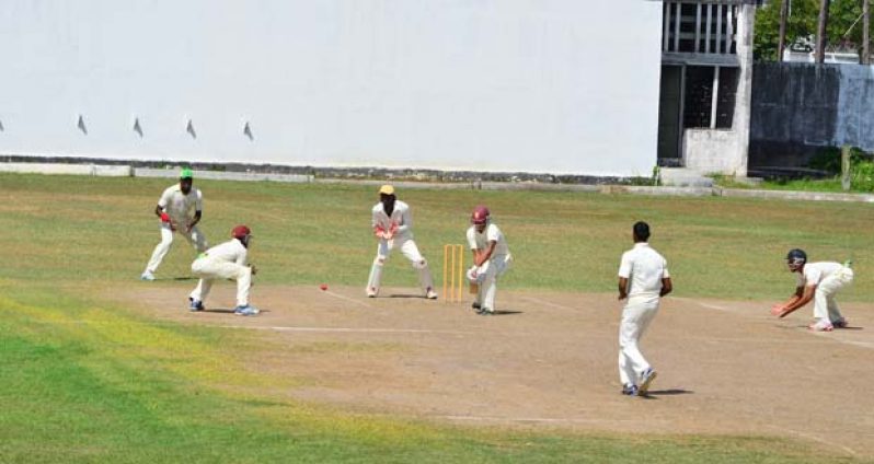 Well played Johnny! Jonathan Foo of Johnson’s XI plays a forward defensive shot against the bowling of Amir Khan (foreground) yesterday, while from left, Shimron Hetmyer, Steven Jacobs, Jason Sinclair (wkp.) and Tagenarine Chanderpaul look on. (Photo by Adrian Narine)