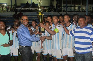 Eagles captain Javair Smith is presented with the winners’ trophy by Sharma Solomon, president UDFA.