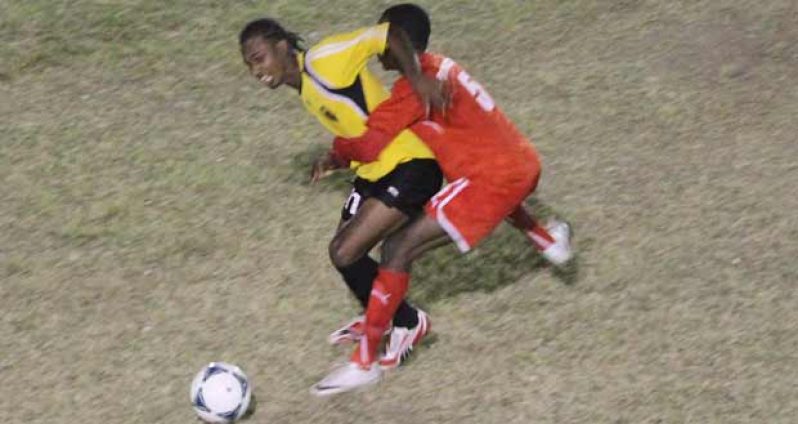 Boys’ Town FC Daemion Benjamin caught holding Alpha United’s Gregory ‘Jackie’ Richardson when the two sides met at the GFC ground. (Sonell Nelson photos)