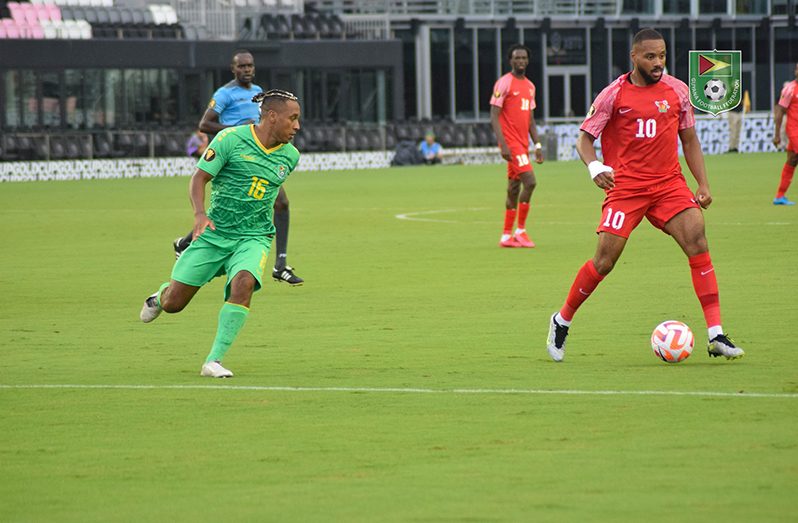 Guyana's Neil Danns (left) trying to dispossess Guadeloupe's Mattias Phaeton in Tuesday's clash