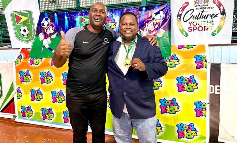 GFF president,  Wayne Forde (left) and Guyana Beverages Inc. General Manager, Samuel Arjoon, celebrate the successful conclusion of the Kool Kidz futsal festival.